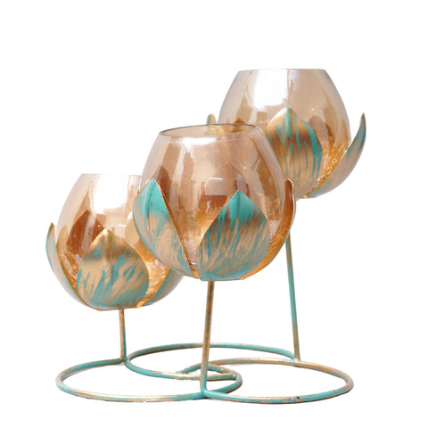 Modern piece of art with metal leaves in antique gold finish with three amber glass candle holders